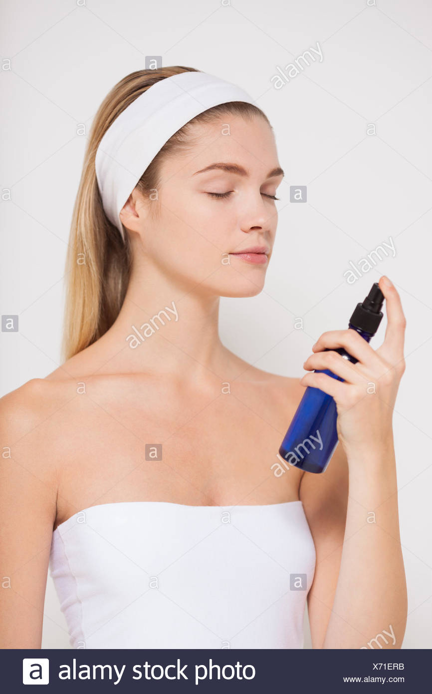 Beautiful woman spraying water on her face Stock Photo