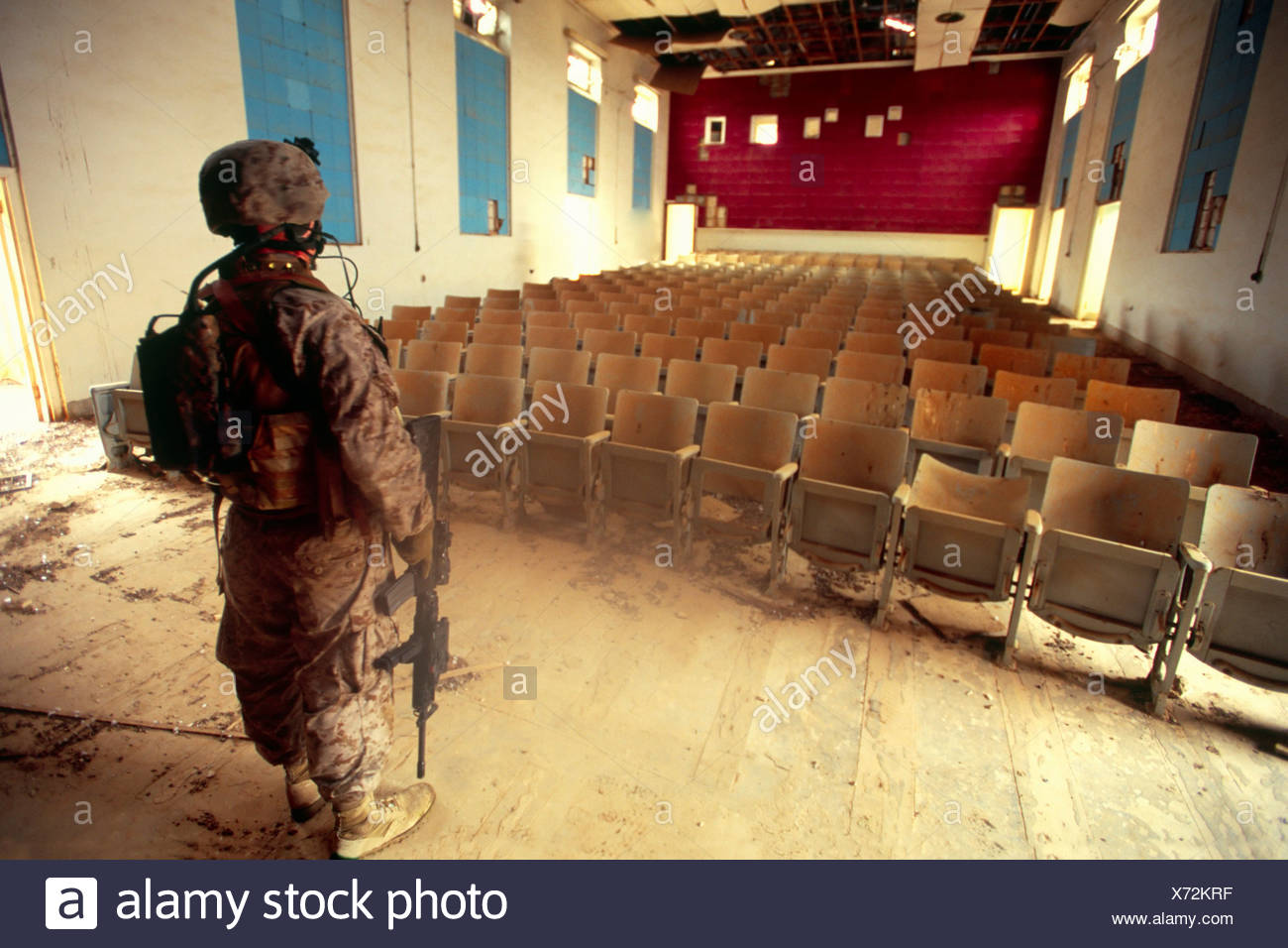 A Us Marine Gazes At The Interior Of An Abandoned Theater At