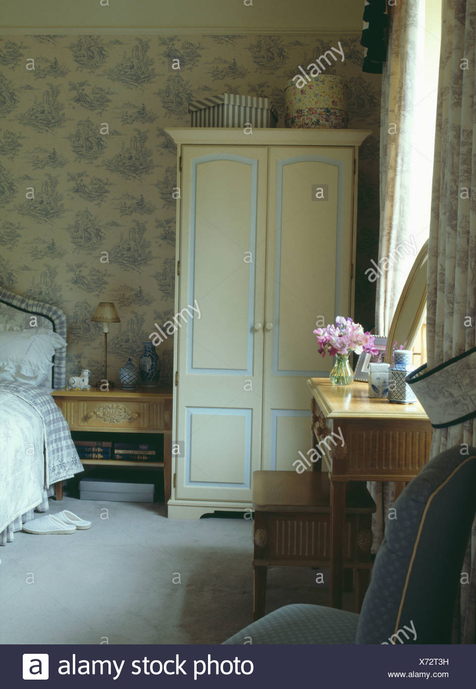 Cream Painted Wardrobe And Patterned Pale Blue Wallpaper In