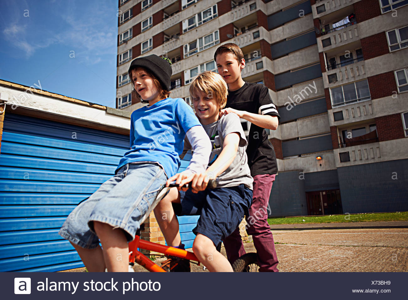 Boy giving two friends a ride on bike Stock Photo