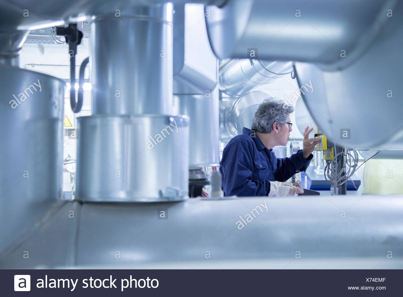 Engineer adjusting control panel in power station Stock Photo