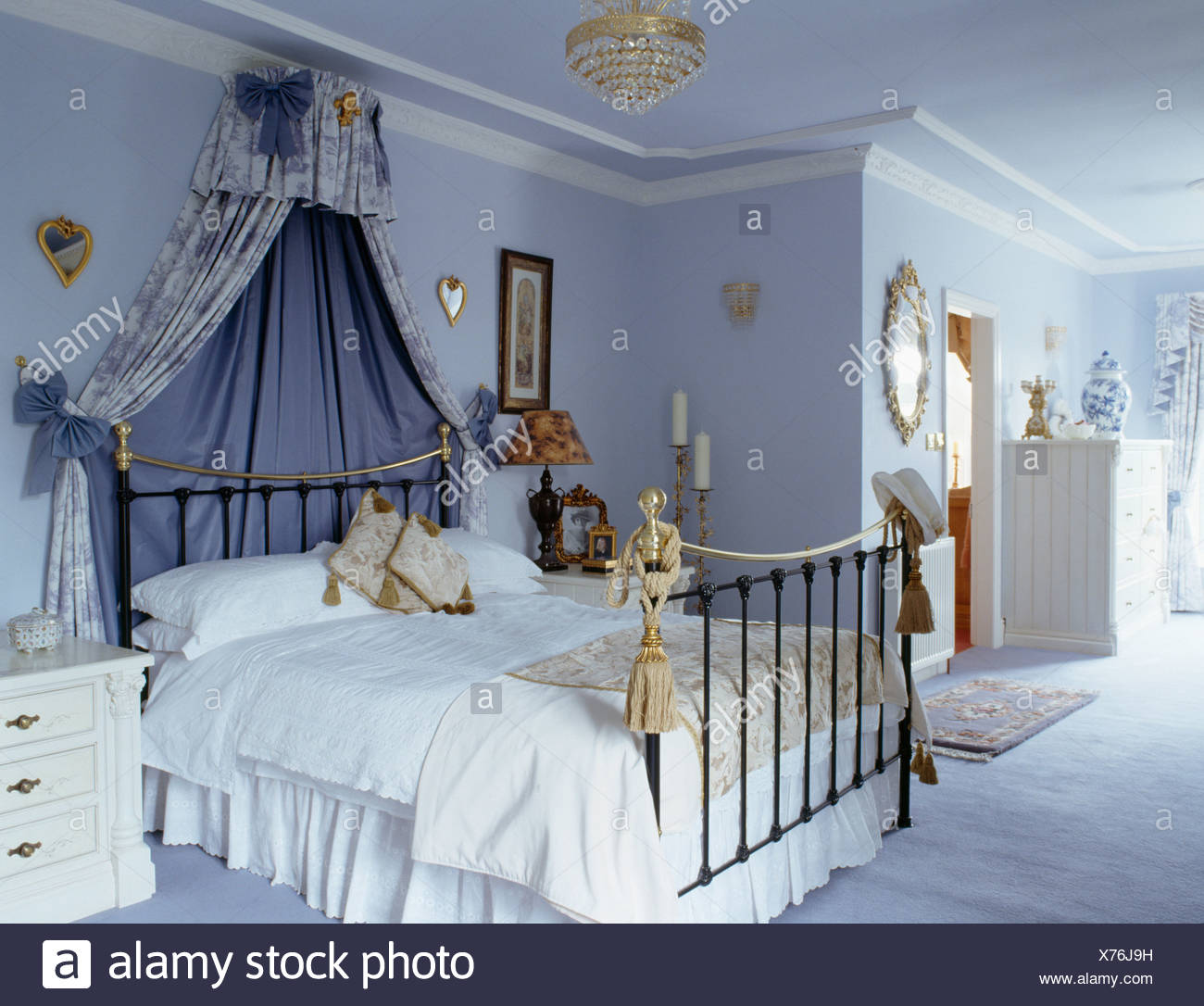Coronet With Blue Drapes Above Brass Bed With White Bedlinen
