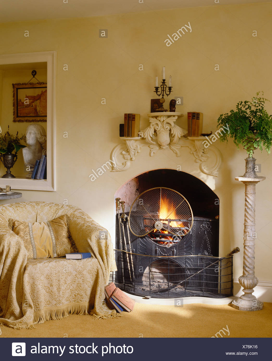 Foliage In Vase On Stand And Armchair With Cream Throw On Either