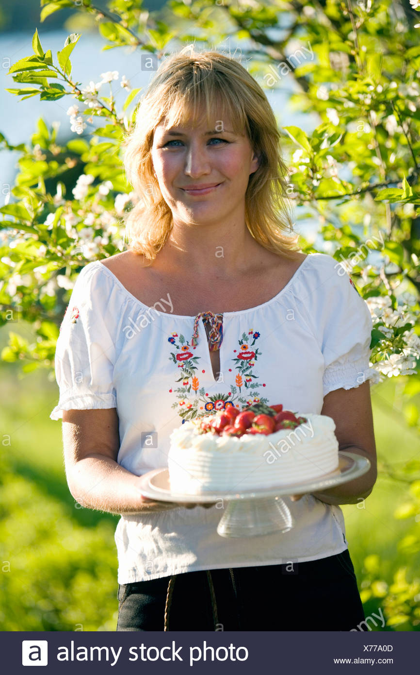 Woman with a strawberry cake, Fejan, Stockholm archipelago, Sweden. Stock Photo