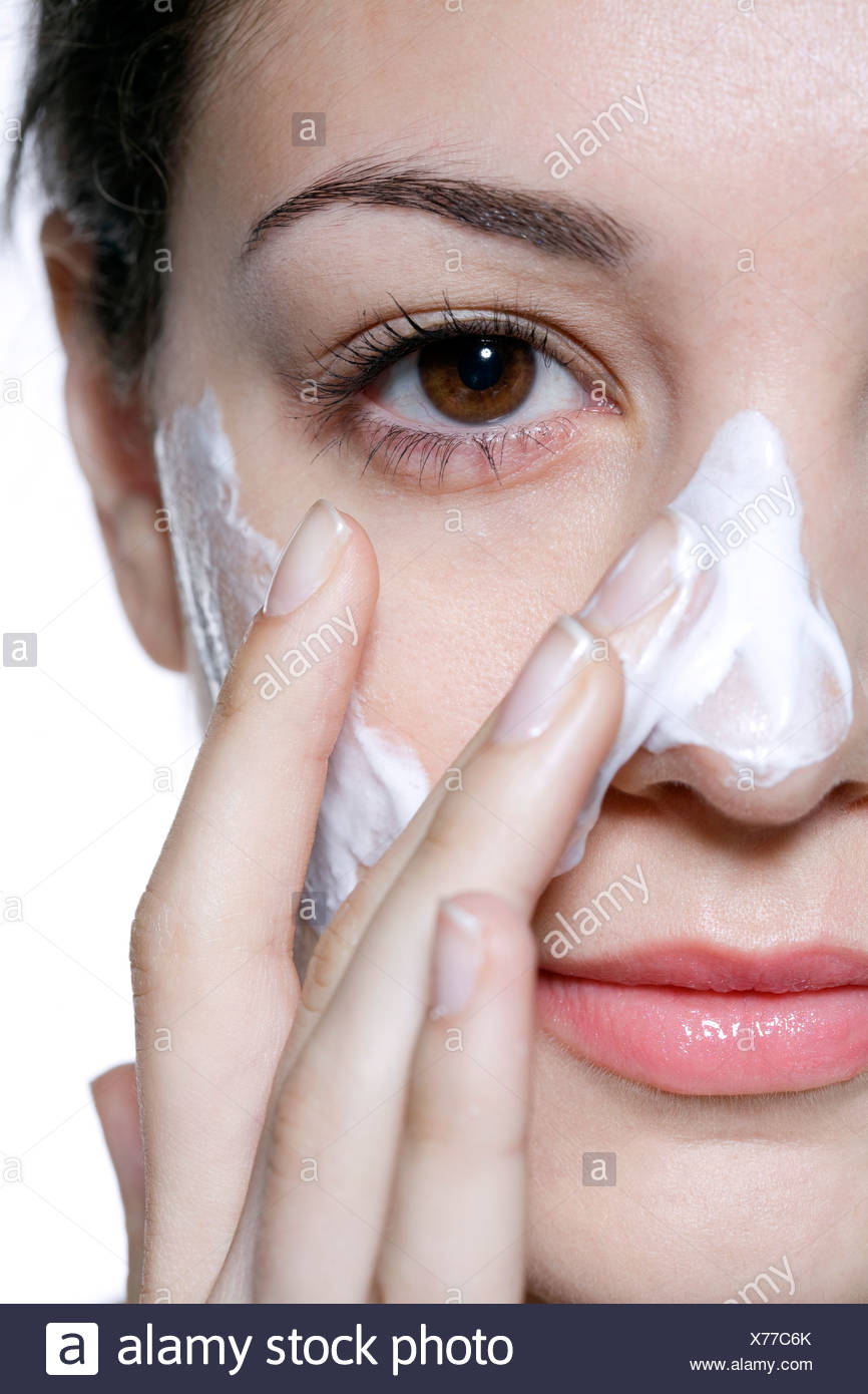 Female Brunette Hair Off Her Face Applying Face Cream To Her Nose
