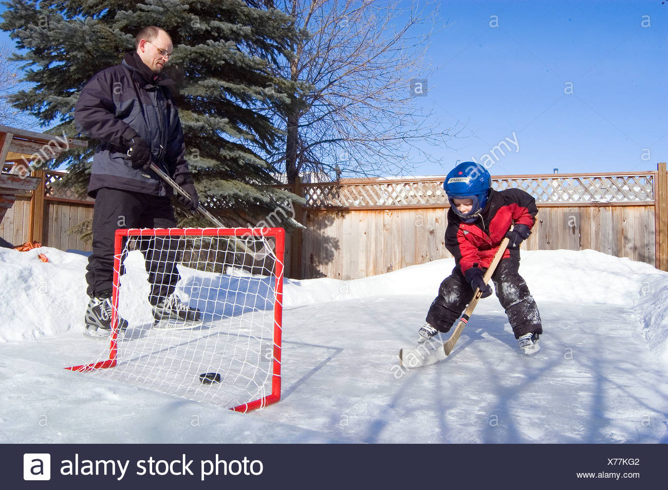 Father And Son Playing Hockey In Backyard Stock Photo 279837490