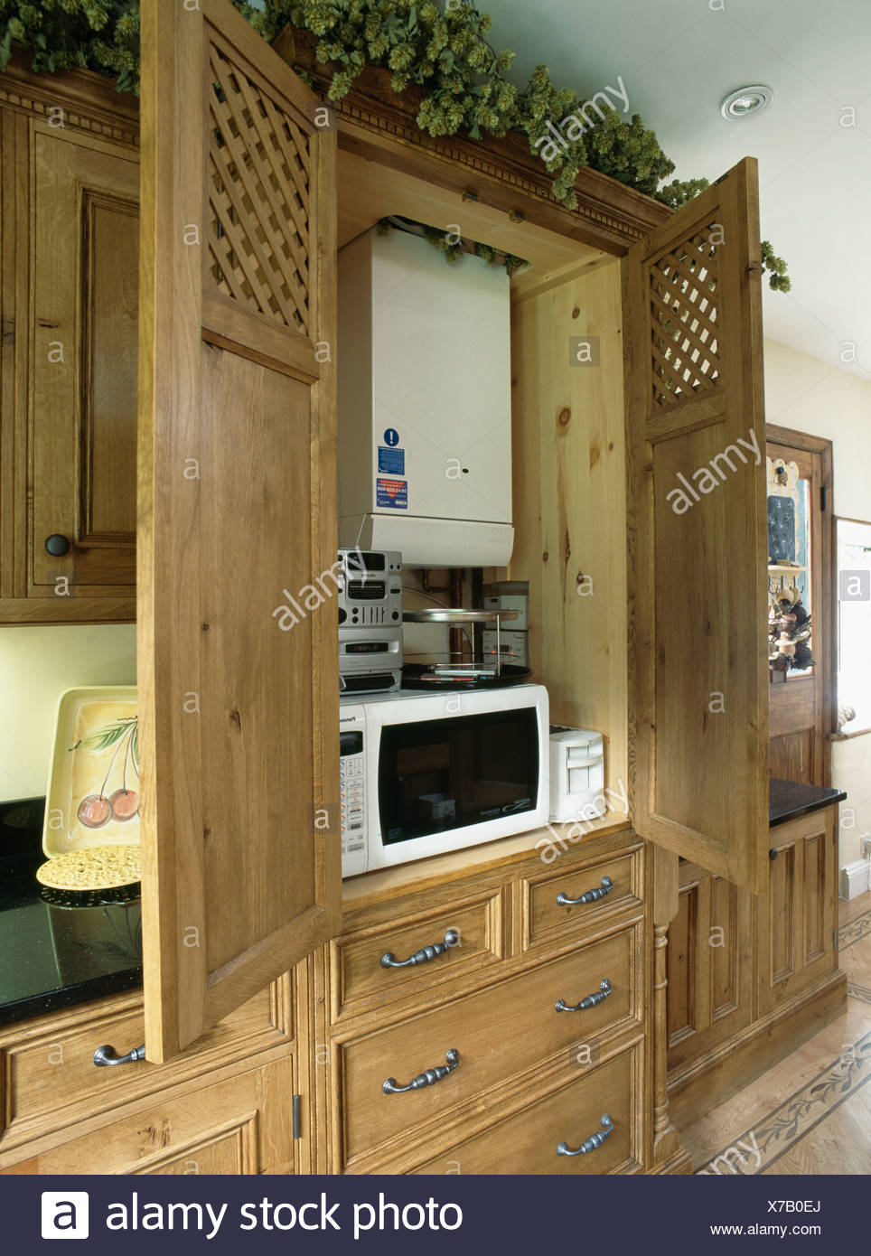 Oak Kitchen Cupboard With Doors Open To Show Central Heating