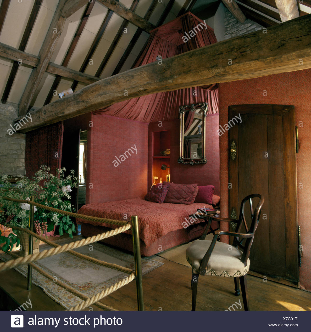 Pink Fabric On Walls In Open Plan Bedroom In Nineties Barn