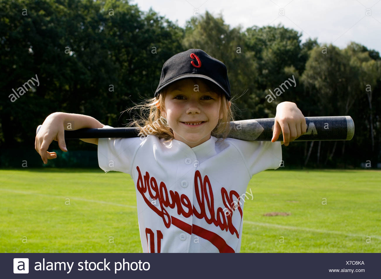 A young girl holding a baseball bat on her shoulders Stock Photo - Alamy