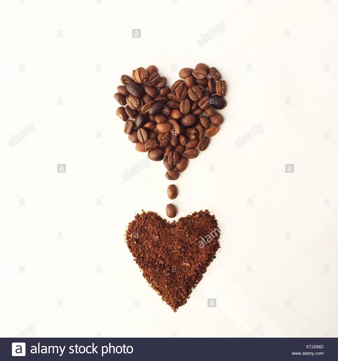 Coffee beans in a heart shape, dripping into another heart shape of ground coffee Stock Photo
