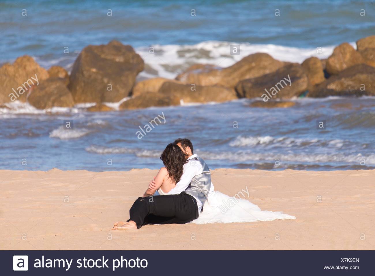 Hugging Couple Kissing On Their Wedding Day On The Beach In Cullera