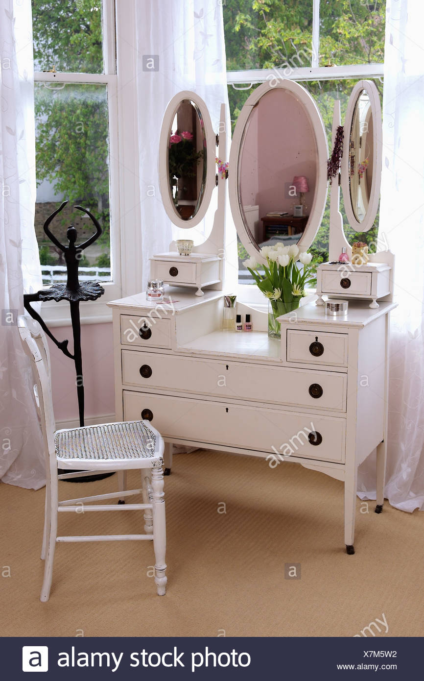 White Dressing Table With Triple Mirrors And White Chair In Front
