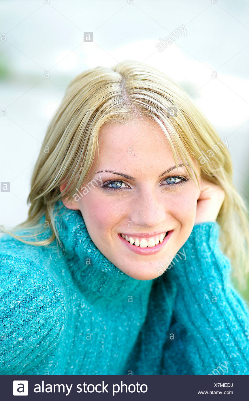 Female With Blonde Hair And Blue Eyes Wearing A Turquoise Rollover