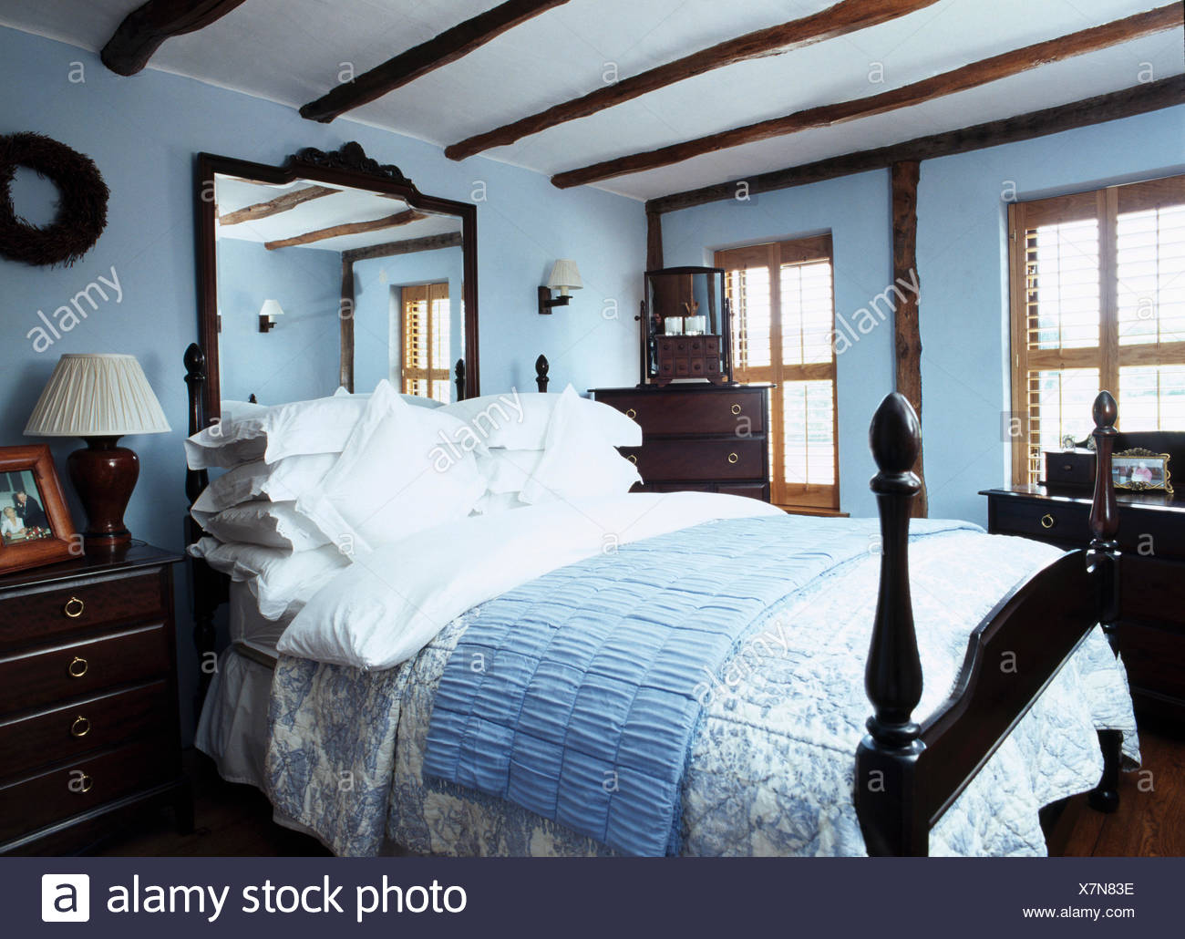 Mirror Above Bed With Quilts And White Pillows In Pastel