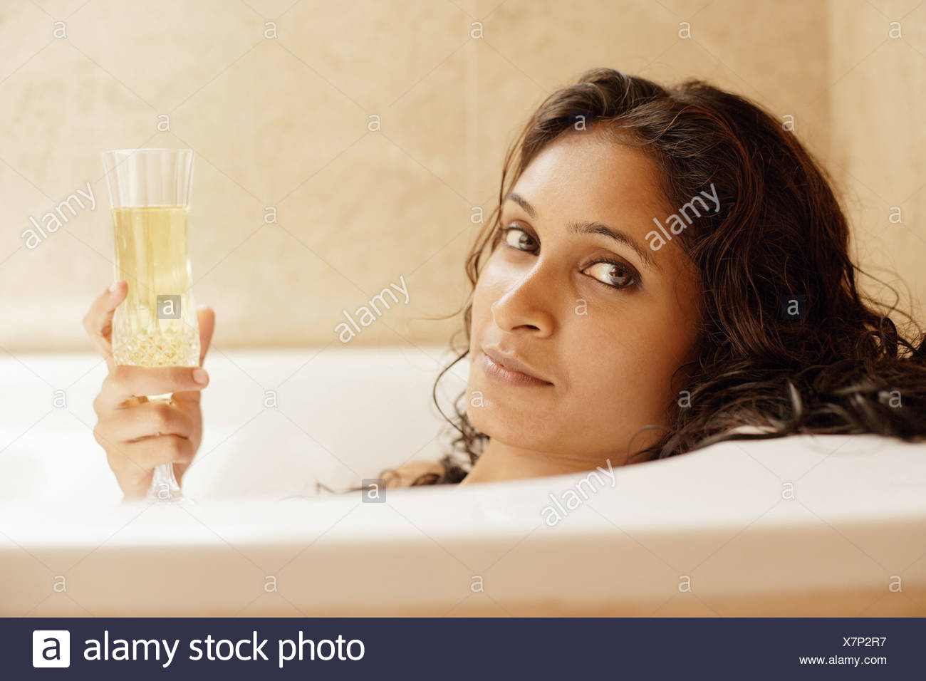 Woman In Bathtub Holding Champagne Glass Stock Photo