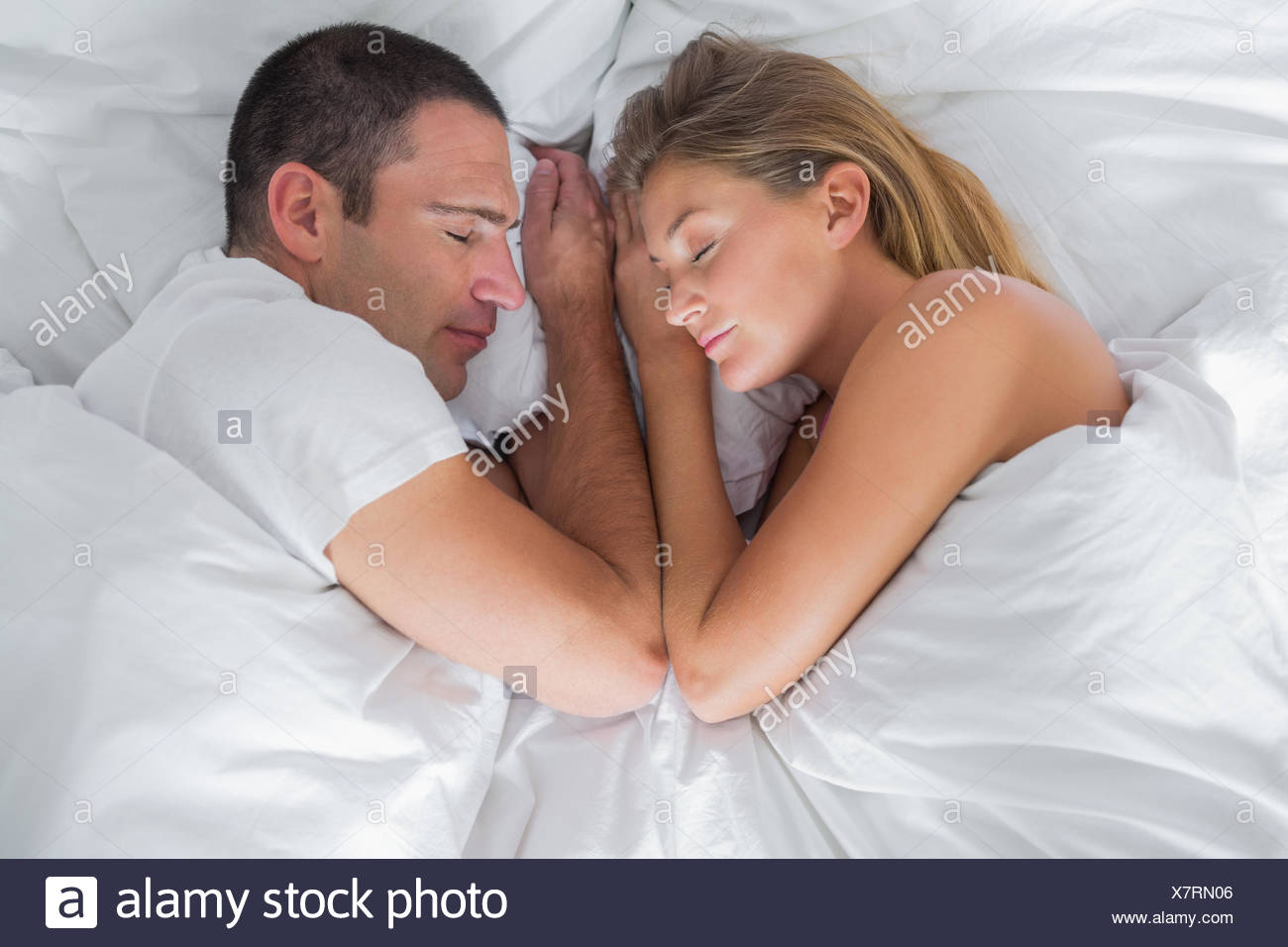 Cute Couple Lying Asleep In Bed At Home In Bedroom Stock
