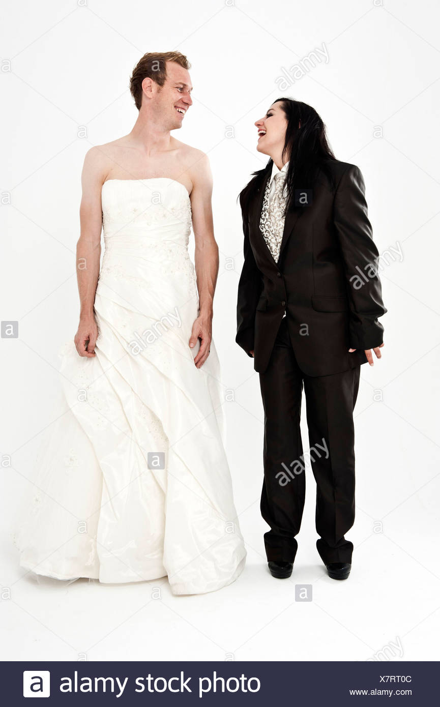 Bride Wearing A Suit And A Groom Wearing A Wedding Dress Smiling