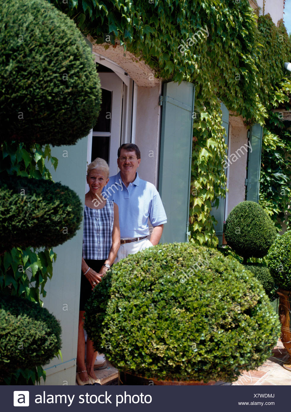 Portrait Of Smiling Couple Standing Outside House With