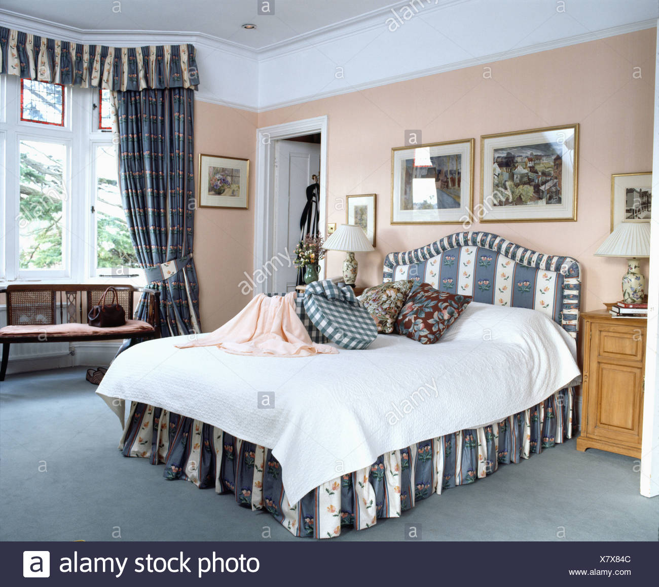 Bedroom With Peach Walls And Bed With Blue Striped Vallance