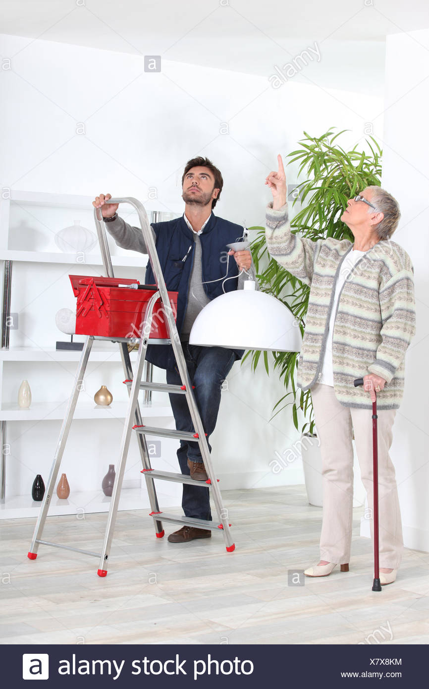 Man Fitting Ceiling Light For Old Lady Stock Photo 280246056 Alamy