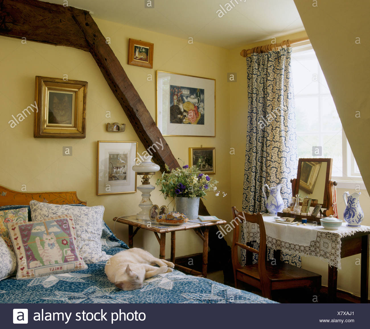 Dog Sleeping On Bed With Cushions And Blue Cover In Cottage