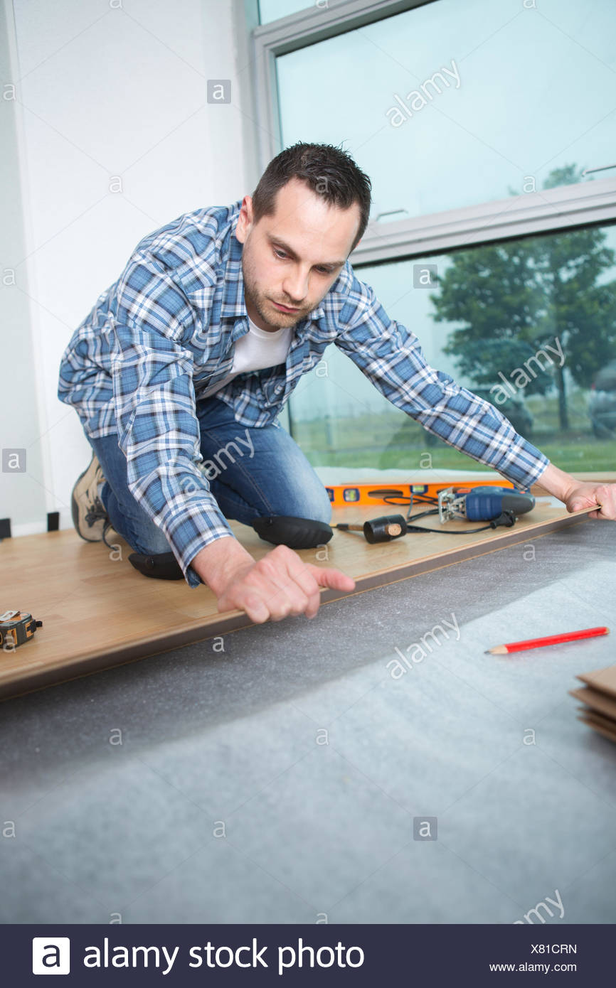 Handyman Laying Down Laminate Wood Flooring Boards Stock Photo