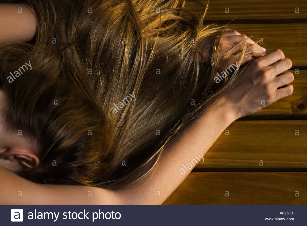 Woman Lying Face Down On Floor Long Hair Covering Arm Cropped