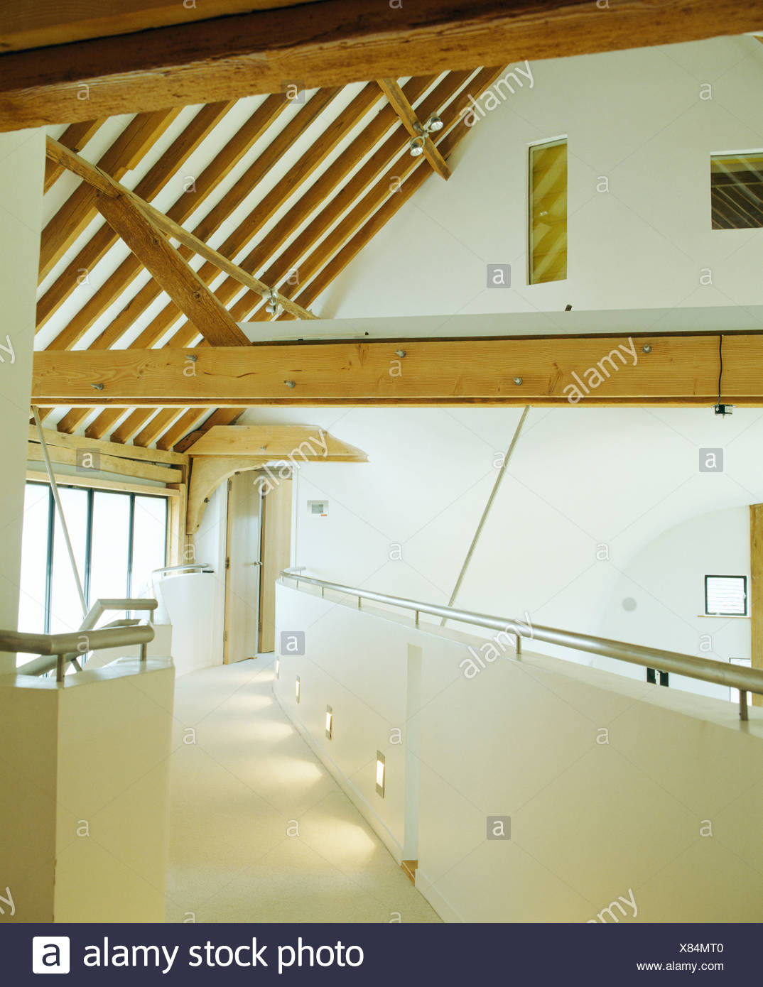 Wooden Ceiling Beams Above White Landing With White Flooring