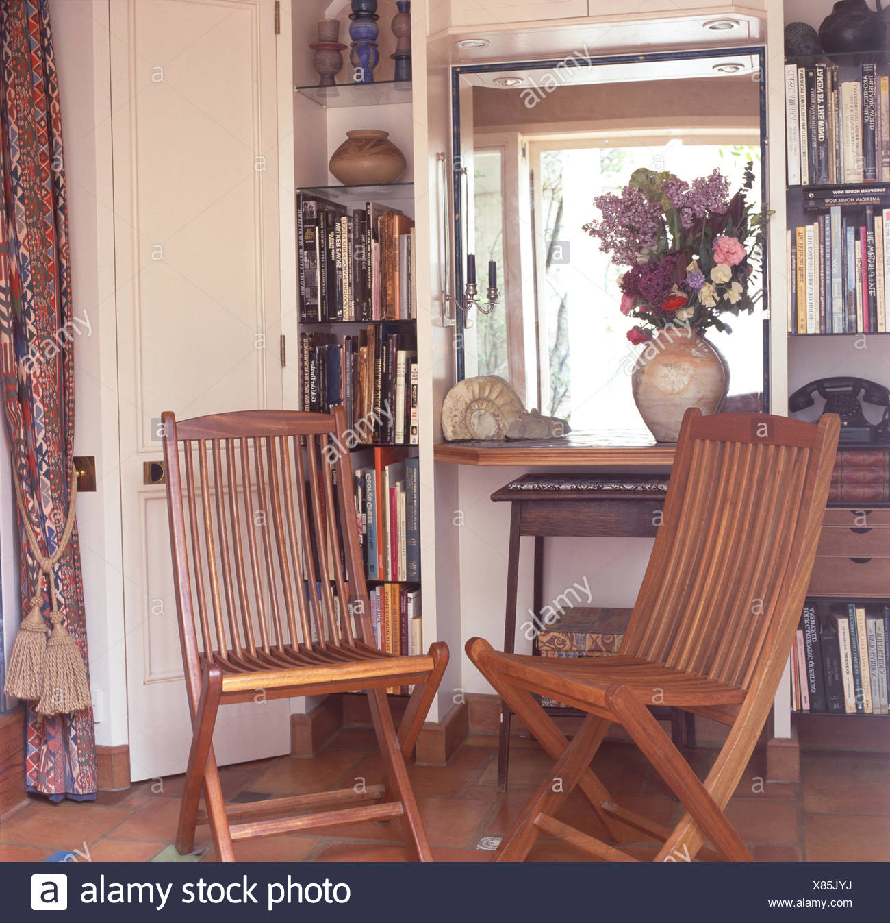 Slatted Wooden Chairs In Front Of A Small Window Between Narrow