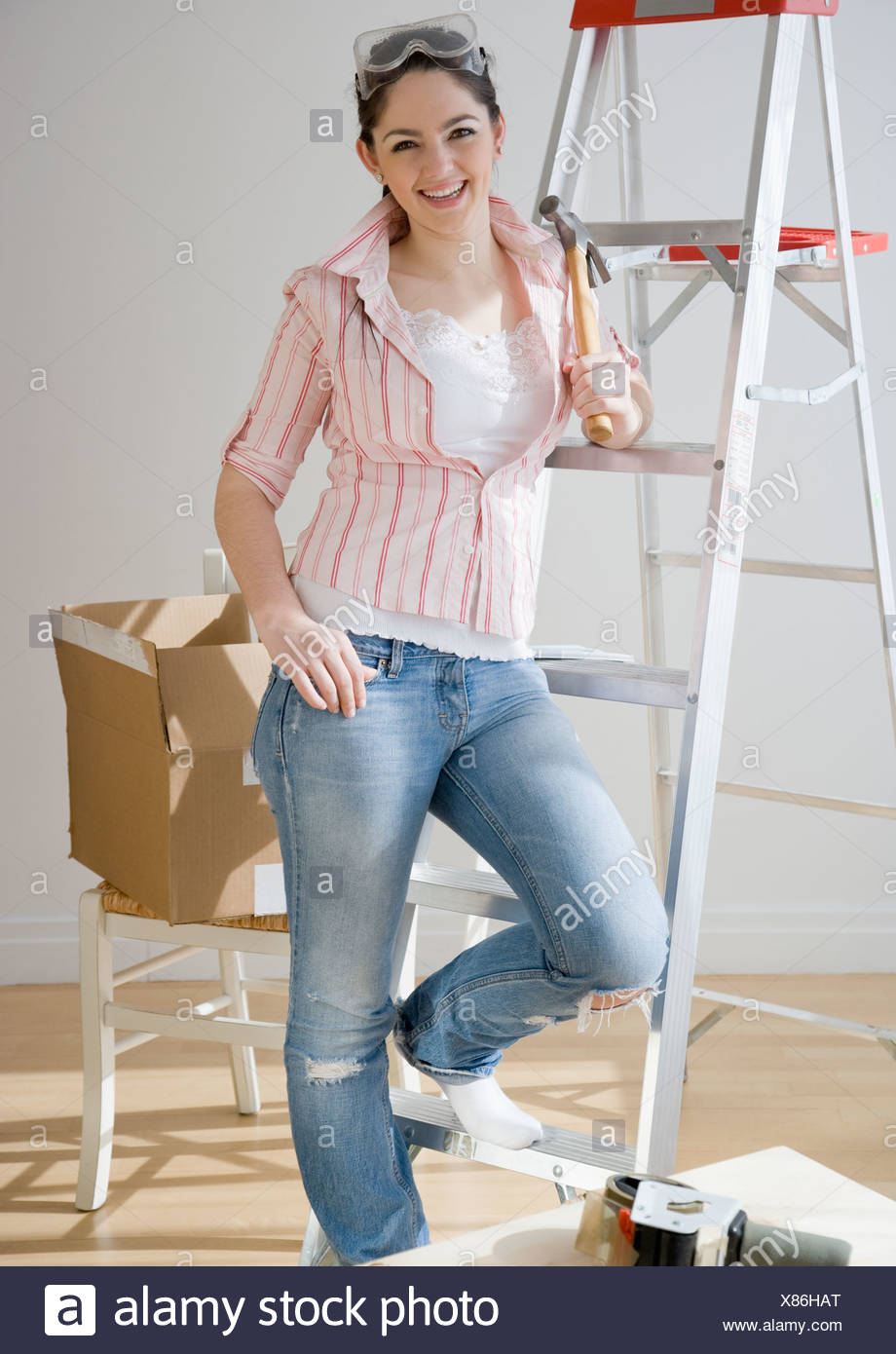 Woman holding hammer next to ladder Stock Photo: 280428480 - Alamy