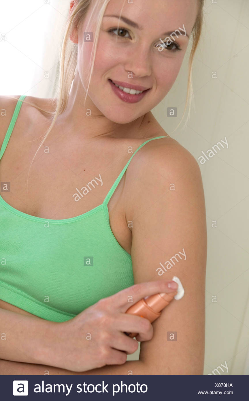 Female Blonde Hair Off Face Wearing Green Bra Top Spraying Fake