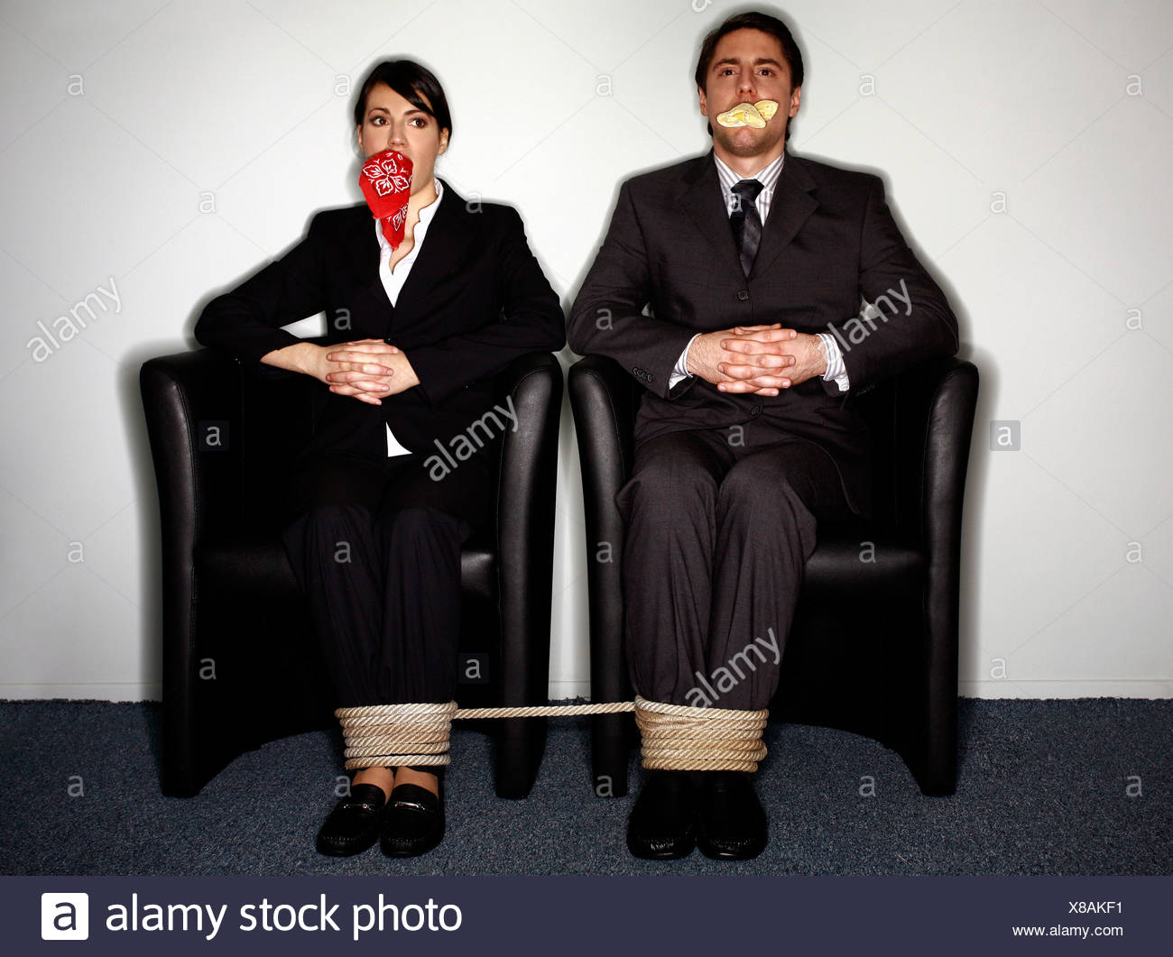 Male and female business people gagged and tied - Stock Image.