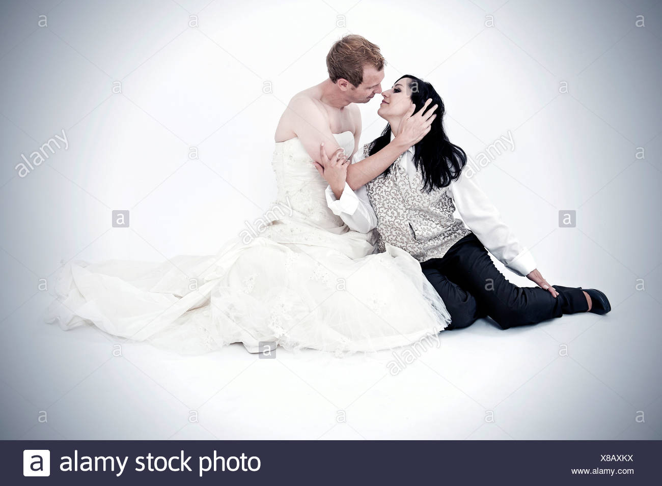 Bride Wearing A Suit Kissing A Groom Wearing A Wedding Dress