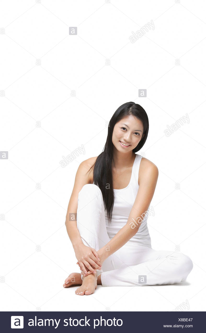 Woman Sitting On Floor Hugging Knee Looking At Camera