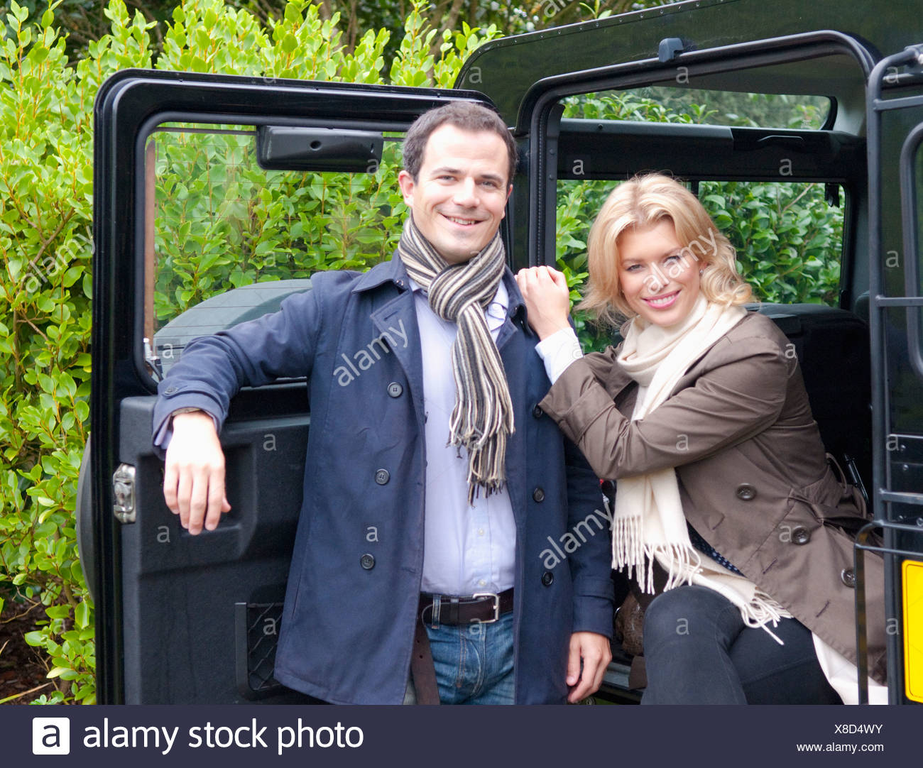 Portrait Of Mid Adult Couple Next To Landrover Door Stock Photo