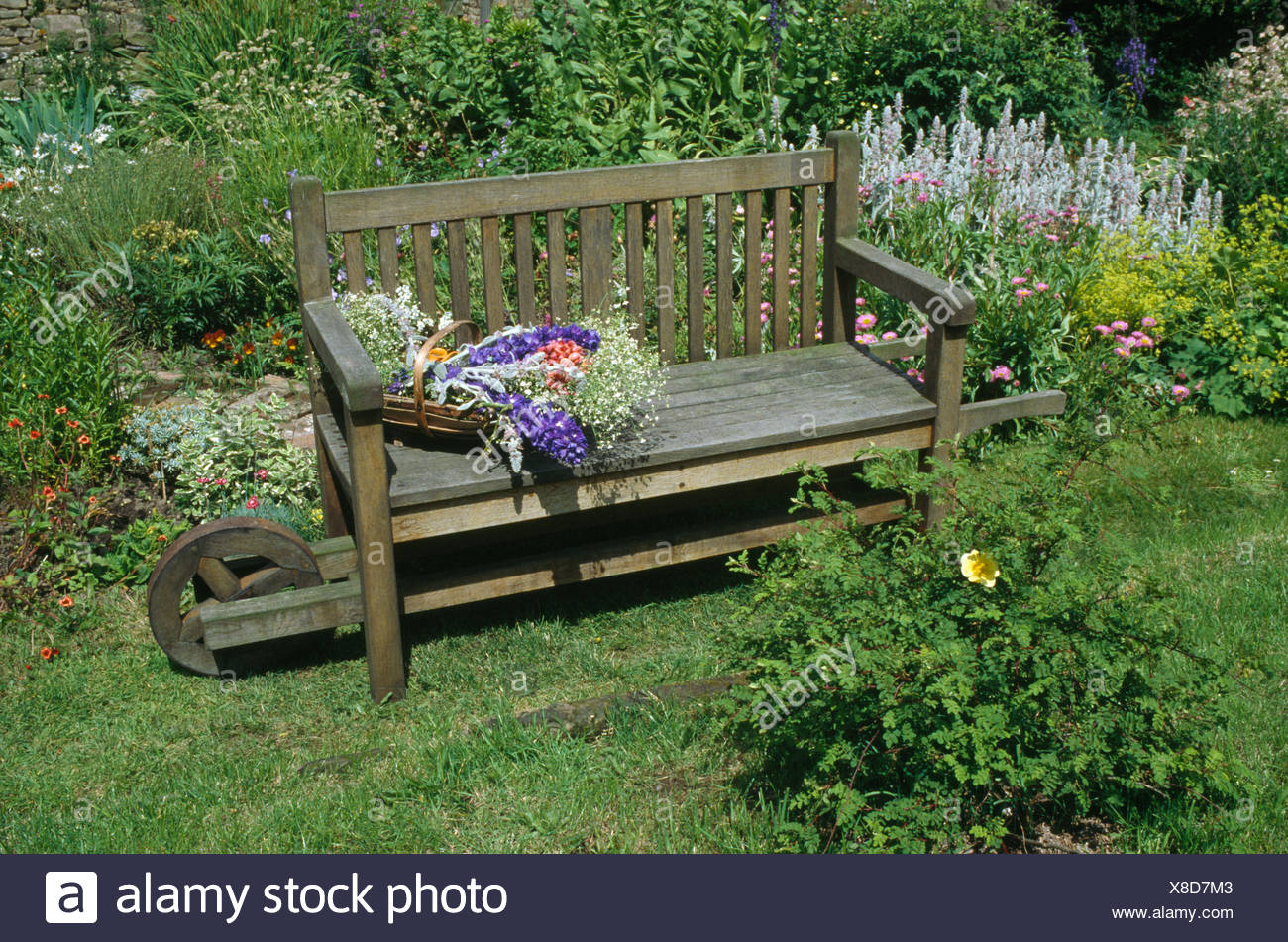 Basket Of Summer Flowers On Rustic Wooden Bench In Country Garden