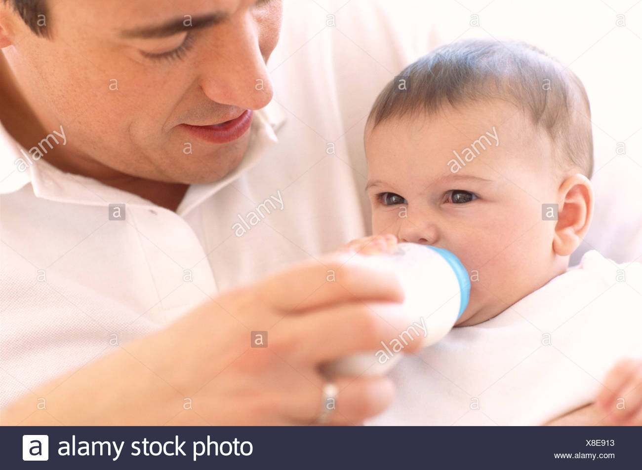 Father Bottle Feeding Baby Father Using A Bottle To Feed Milk To