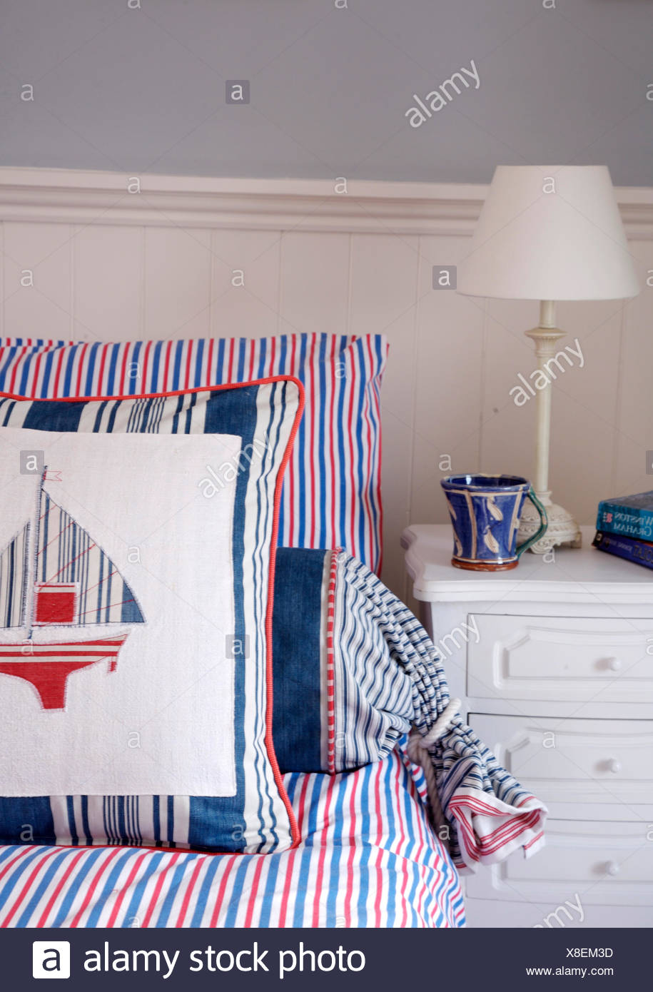 White Lamp On Painted Table Beside Bed With Red White And