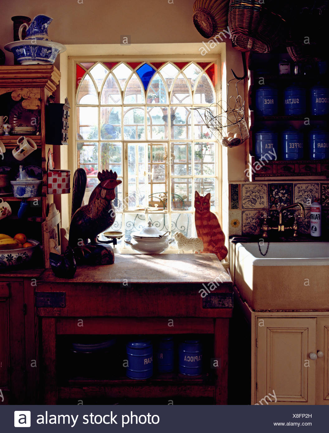 Gothic Style Window With Stained Glass Inserts Above Ceramic Sink