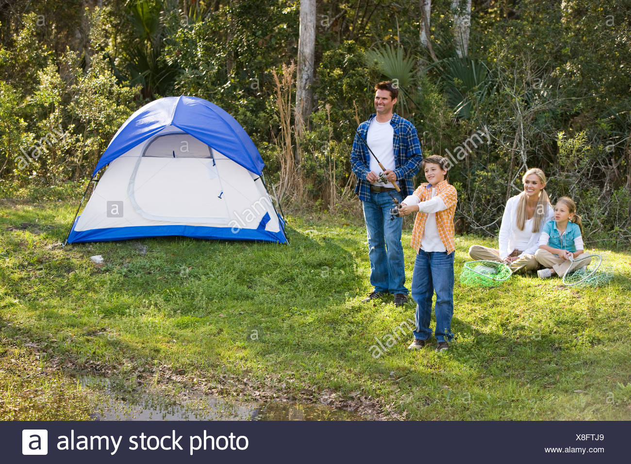 Family On Camping Trip Fishing By Tent Stock Photo Alamy