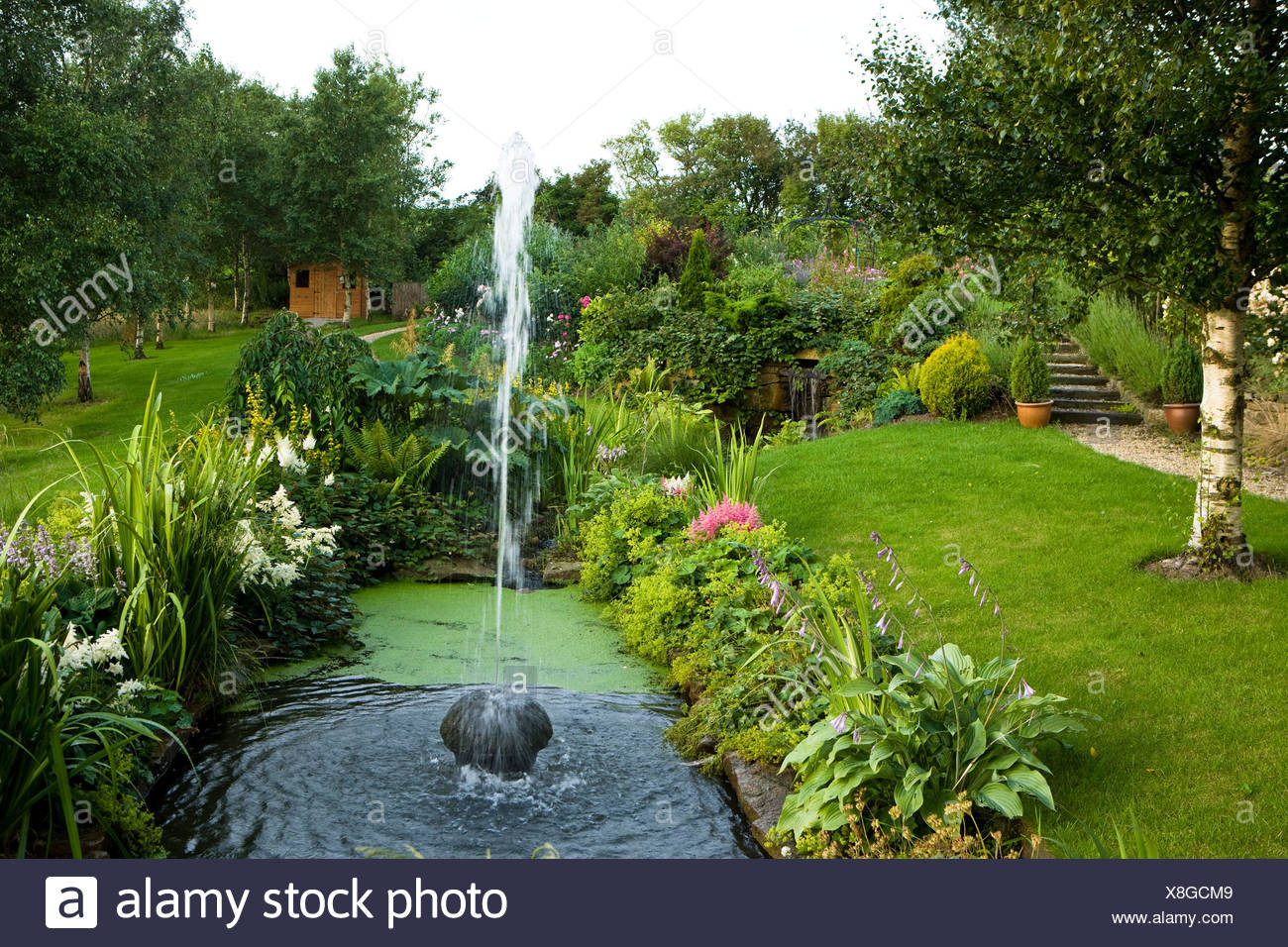 Stone Fountain In A Small Garden Pond Stock Photo Alamy