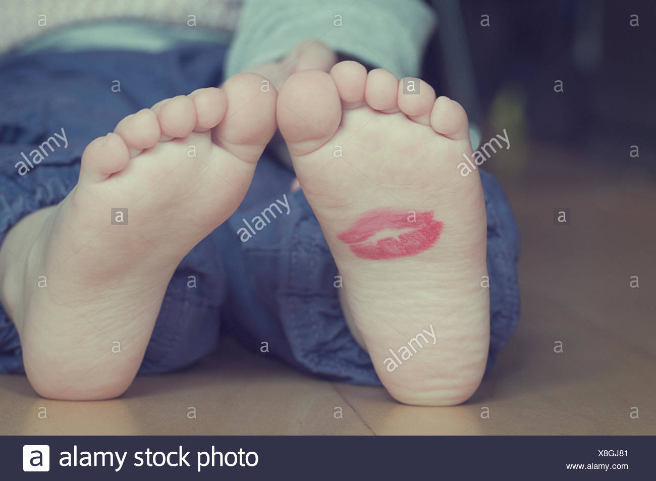 Lipstick kiss on toddler's foot Stock Photo