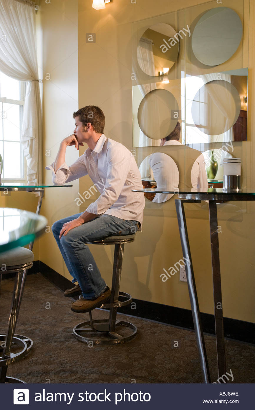Serious Man Sitting On Stool Stock Photos & Serious Man Sitting On