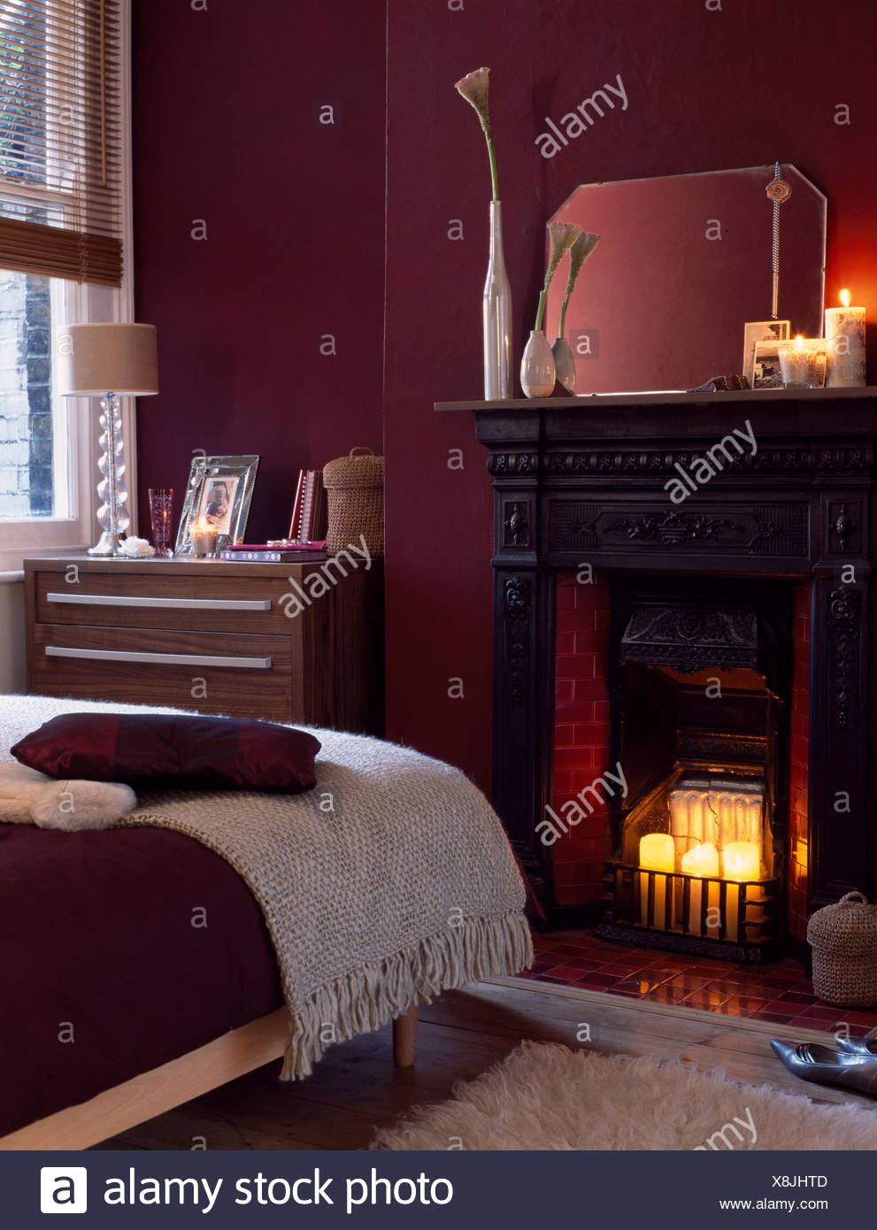 Candles In Victorian Fireplace In Aubergine Bedroom Stock Photo