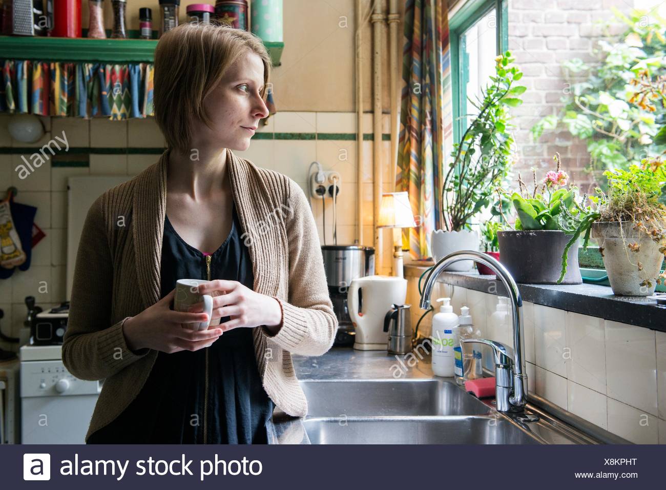 Tilburg Netherlands Adult Caucasian Woman Drinking A Cup Of Tea While Leaning Against A Vintage Kitchen Sink Stock Photo Alamy