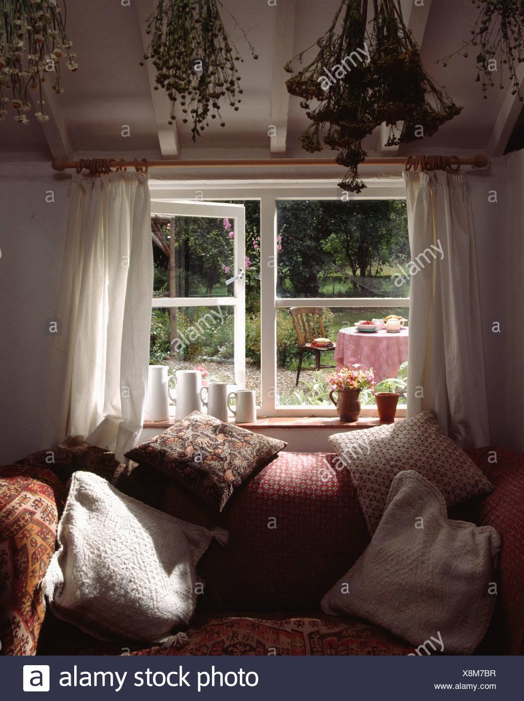 Cottage Livingroom With Comfy Sofa Below Open Window With View Of