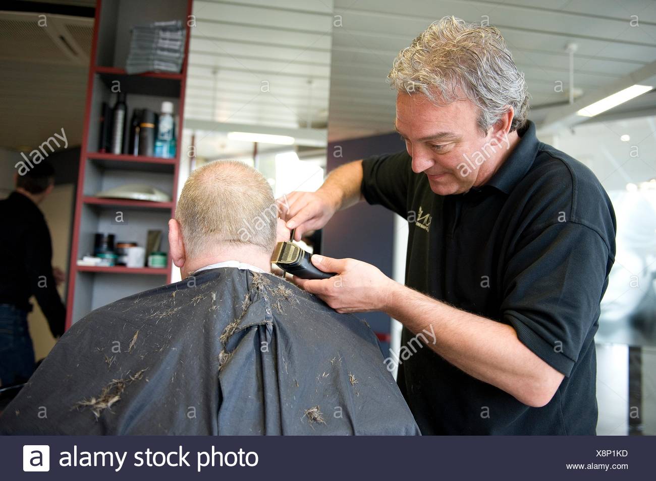 A Barber Giving A Male Customer A Haircut Stock Photo