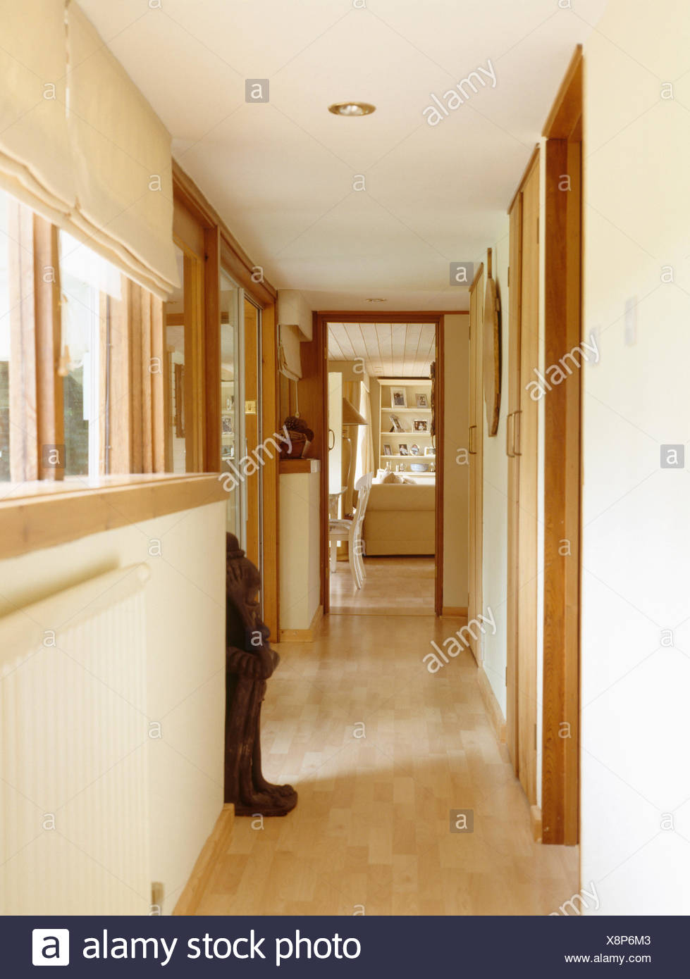 Pale Wood Flooring In Narrow Hall With Door Open To Living