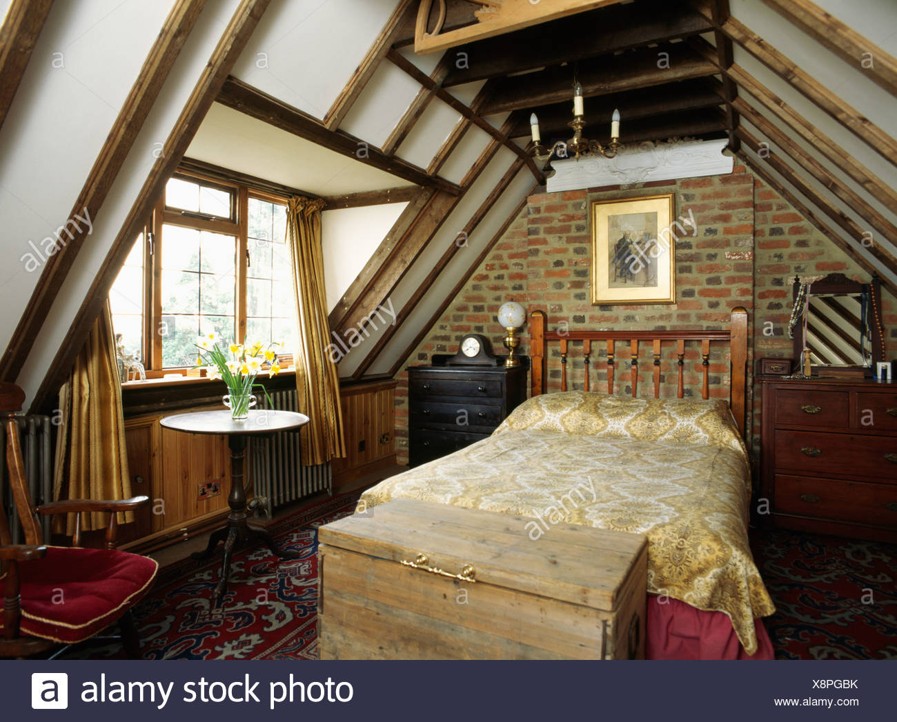 Wooden Chest Below Bed In Attic Bedroom With Brick Wall And