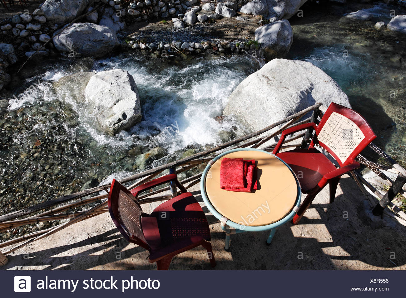 Two Red Chairs And A Table At A Restaurant Patio Overlooking